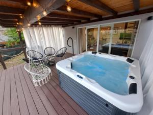 a hot tub on a deck with a table and chairs at SpaHouse Adrian in Dobrodol