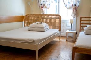 1 dormitorio con 2 camas y una ventana con cortinas en Trzy Kafki Private Rooms, en Cracovia