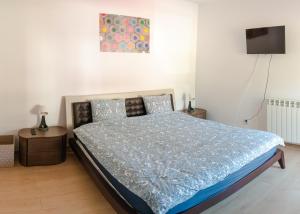 een slaapkamer met een bed met een blauw dekbed bij Casa Bear Azuga in Azuga