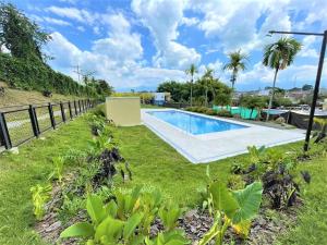 a backyard with a swimming pool and a fence at Apartamento 205 torre C Reserva de la Colina La Tebaida Quindio in La Tebaida