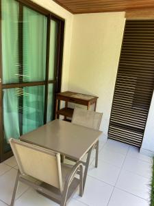 a table and two chairs on a balcony with a table at Barra Beach Iloa Residence - Flat 001V in Barra de São Miguel