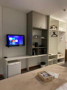 a living room with a tv on a wall at Barra Beach Iloa Residence - Flat 001V in Barra de São Miguel