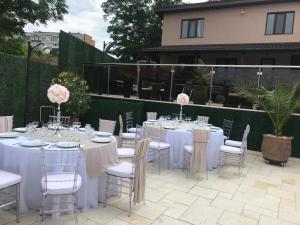 a set of tables and chairs with pink flowers on them at La Strada in Onești