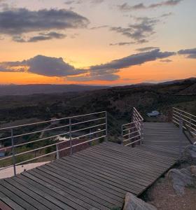 una terraza de madera con una puesta de sol en el fondo en Lambisco- Alojamento local, en Alfândega da Fé