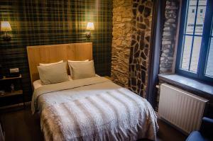 a bedroom with a bed and a stone wall at B&B Au Canard in La Roche-en-Ardenne