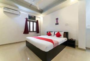 a bedroom with a large bed with red pillows at OYO HOTEL FORTUNE BLISS in Hyderabad