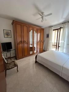 1 dormitorio con 1 cama grande y TV en Appartamento tra il borgo e il lago, en Anguillara Sabazia