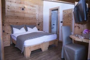 a bedroom with a bed and a flat screen tv at B&B The King in Livigno