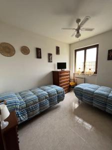 Sala de estar con 2 camas y TV en Appartamento tra il borgo e il lago, en Anguillara Sabazia