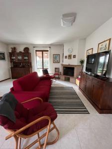 sala de estar con sofá rojo y TV en Appartamento tra il borgo e il lago, en Anguillara Sabazia