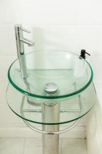 een glazen tafel met een wastafel in de badkamer bij Ping-Pong Paradise in Crawley