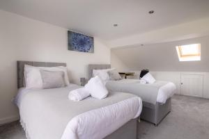 una camera con due letti con lenzuola bianche di Ping-Pong Paradise a Crawley