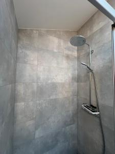 a shower with a shower head in a bathroom at Stripeikių Bitė in Varniškės I