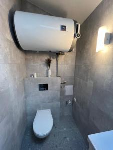 een badkamer met een wit toilet en een wastafel bij Stripeikių Bitė in Varniškės I