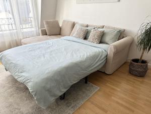 1 cama en la sala de estar con sofá en Comfy apartment near La Defense - West of Paris en La Garenne-Colombes