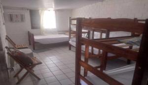 een kamer met meerdere stapelbedden en een raam bij Hostel Casa Amarela in Porto De Galinhas