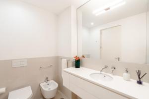 a white bathroom with a sink and a mirror at VIVA Nanda's Place in Porto