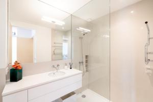 a white bathroom with a sink and a shower at VIVA Nanda's Place in Porto