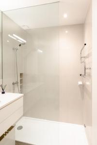 a white bathroom with a shower and a sink at VIVA Nanda's Place in Porto +15 photos