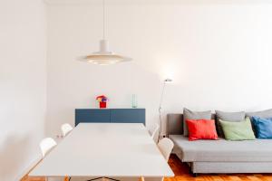 a white table and a couch in a room at VIVA Nanda's Place in Porto