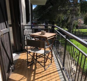 una mesa de madera y una silla en el balcón en Appartamento nel verde a Gravere, en Gravere