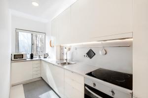 a white kitchen with a stove and a sink at VIVA Nanda's Place in Porto