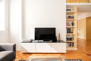 a living room with a tv on a white cabinet at VIVA Nanda's Place in Porto
