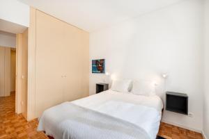 a bedroom with a white bed and a tv at VIVA Nanda's Place in Porto