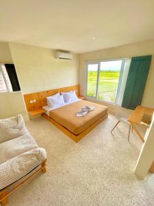 a bedroom with a bed and a large window at TANAWU AIRPORT HOTEL LOMBOK in Praya