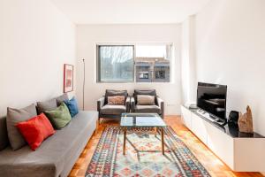 a living room with a couch and a tv at VIVA Nanda's Place in Porto