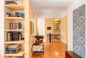 a room with a chair and bookshelves at VIVA Nanda's Place in Porto