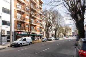 a white car parked on the side of a city street at VIVA Nanda's Place in Porto