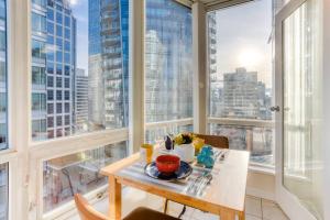 uma mesa e cadeiras num quarto com janelas em lean & Cozy 1 Bedroom by Convention Center incl. Parking em Vancouver