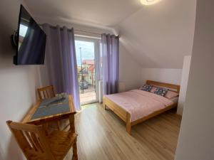 a small bedroom with a bed and a window at Willa Kinga in Władysławowo