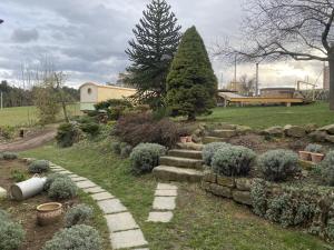 a garden with a stone path and a tree at Chez Sophie et Gilles in Monistrol-sur-Loire