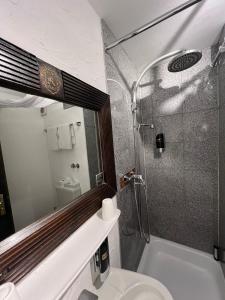 a bathroom with a shower and a toilet and a sink at Runa´s Hotel in Hallbergmoos