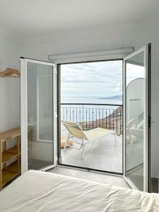 um quarto com uma cama e uma varanda com uma cadeira em 'Home Sweet Home-Tabaiba-Tenerife’ em Santa Cruz de Tenerife