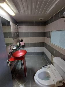 łazienka z czerwoną umywalką i toaletą w obiekcie Residence Yeoyu w mieście Guri