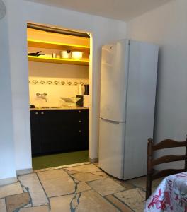 a kitchen with a white refrigerator in a room at Appartamento nel verde a Gravere in Gravere