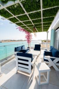 a patio with chairs and tables and a view of the ocean at Tiffany Beach in Durat  Alarous