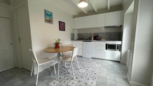 una cucina con un tavolo e sedie in una stanza di La maisonnette de Julien - 3 étoiles a Ceyrat
