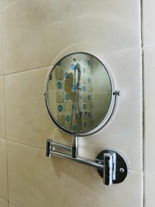 Le Majorelle Cozy Flat في مراكش: مرآة على جدار الحمام مع دش