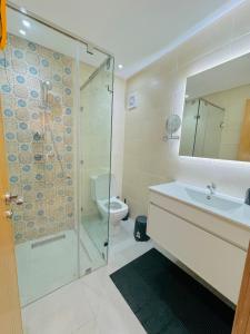 La salle de bains est pourvue d'une douche, d'un lavabo et de toilettes. dans l'établissement Le Majorelle Cozy Flat, à Marrakech