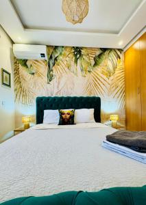 Le Majorelle Cozy Flat في مراكش: غرفة نوم مع سرير أبيض كبير مع ورق جدران استوائي