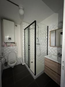 uma casa de banho com um chuveiro, um WC e um lavatório. em Vitry em Vitry-sur-Seine