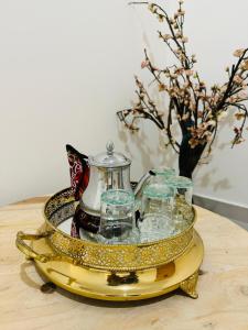 Le Majorelle Cozy Flat في مراكش: صينية مع وعاء الشاي والاكواب على طاولة