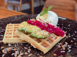 a waffle and ice cream on a black plate at Munduk Tjeraki House in Munduk