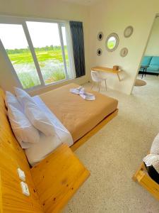 a bedroom with a large bed with a large window at TANAWU AIRPORT HOTEL LOMBOK in Praya