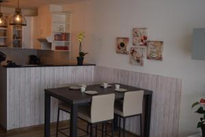 a black table with white chairs in a kitchen at Apartment Aurora in Ieper