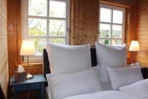 um quarto com almofadas brancas e uma cama com janelas em Loft 18 em Schlitz